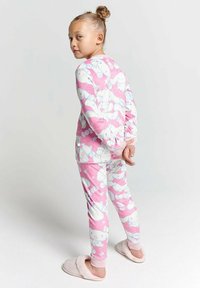 Pink pajama set featuring long sleeves and pants, adorned with white cartoon animal patterns. Soft fabric with a cozy texture.