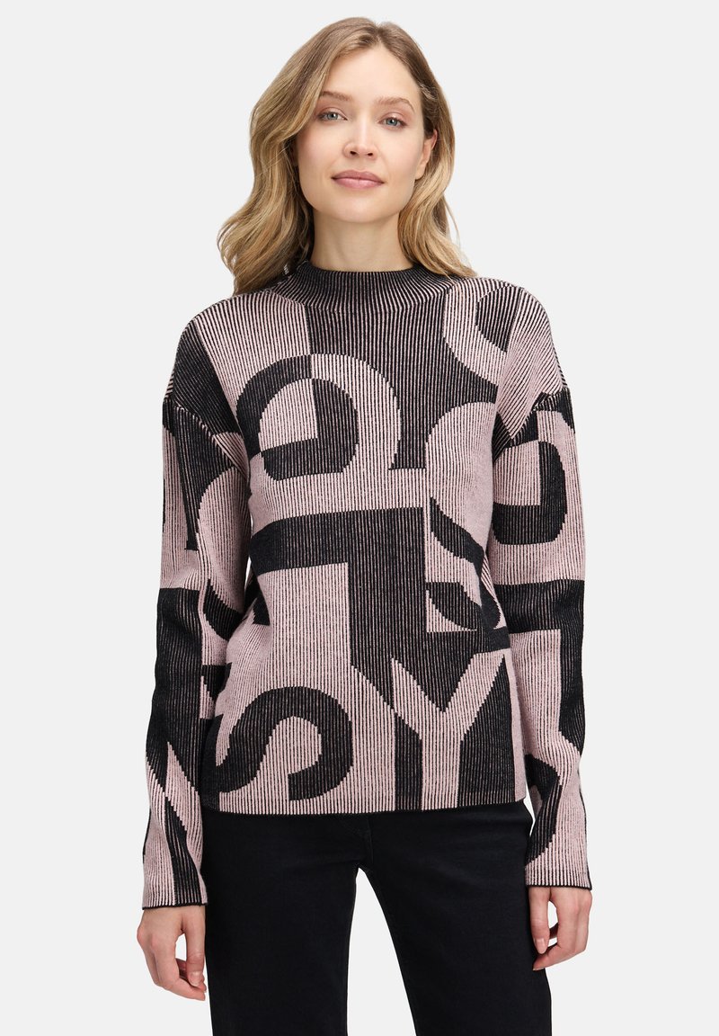 Strickpullover mit gerippter Textur, schwarz-rosa Farbschema und auffälligen grafischen Buchstaben. Lange Ärmel und hoher Kragen.