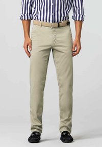 Light beige chinos with a straight cut, made from cotton blend fabric. Styled with a woven tan belt and dark loafers. Vertical striped shirt visible.