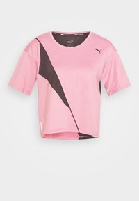 Kortärmad träningstopp i rosa med en kontrasterande svart diagonalkant. Har en rund halsringning och ett luftigt tyg.