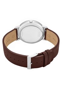 Silberner Edelstahl-Uhrenboden mit einem braunen Lederband. Das Band hat eine strukturierte Oberfläche und eine Metallschließe mit eingraviertem Markennamen.