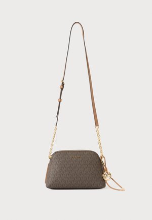 Καφέ τσάντα Michael Kors χιαστί με χρυσές αλυσίδες και ρυθμιζόμενο δερμάτινο λουρί, με στρογγυλό χρυσό κρεμαστό λογότυπο.