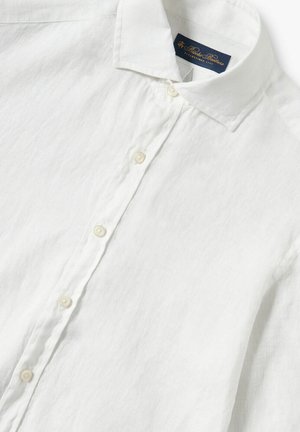 Weißes Leinenhemd mit Button-Down-Kragen, das eine vertikale Textur und perlfarbene Knöpfe entlang der Vorderseite aufweist. Etikett innen am Kragen sichtbar.
