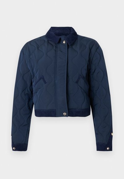 Veste matelassée bleu marine avec col en velours côtelé, fermeture à boutons-pression, poches latérales, poignets à boutons-pression et coupe courte.