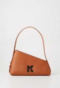 Leather handbag in warm tan, angular design with a slender shoulder strap. Features a black "K" logo on the front. Smooth texture.
