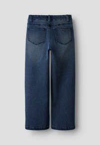 Jeans de denim en azul oscuro con un diseño de pierna recta, cinco bolsillos y costuras visibles en la cintura y las costuras.
