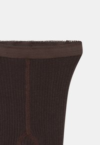 Leggings castanhos de malha com uma textura canelada e um acabamento de renda decorativa na cintura, apresentando um acabamento suave e detalhes de costura central.