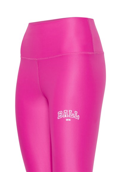 Uske prilagođene, visokog struka tajice u svijetlo ružičastoj boji s glatkom teksturom. Imaju odvažno bijelo ispisano slovo "BALL 1976" na bedru.