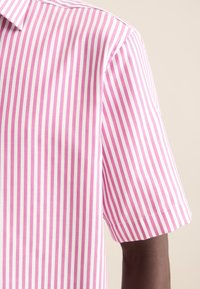Camicia a maniche corte con strisce verticali rosa e bianche. Tessuto in cotone morbido, colletto a punta e dettagli sulle cuciture laterali.