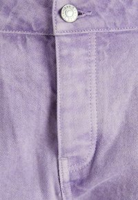 Tecido de algodão roxo com uma leve textura, apresentando um botão prateado na cintura e costuras ao longo da frente e das bordas dos bolsos.
