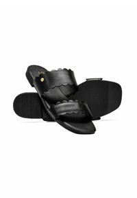 Czarne skórzane klapki z falistymi paskami i złotymi akcentami. Płaska gumowa podeszwa o teksturowanej powierzchni dla lepszej przyczepności.