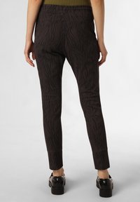 Schwarze Leggings mit Muster in engen Schnitt, die ein strukturiertes Design aufweisen, das Baumästen ähnelt. Glatter Stoff und mittelhoher Bund.