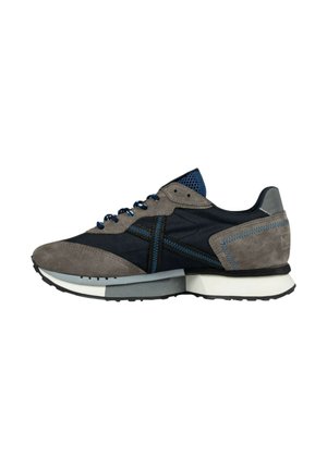 Zapatillas deportivas en gris y azul marino, confeccionadas en ante y malla, con paneles texturizados, costuras en contraste y una suela blanca con tacos negros.