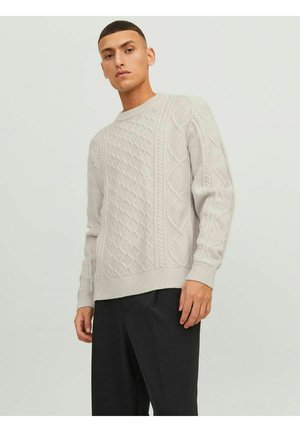 Light grey knitted sweater featuring a textured diamond and cable pattern, crew neckline, and ribbed cuffs and hem. Worn with black trousers.