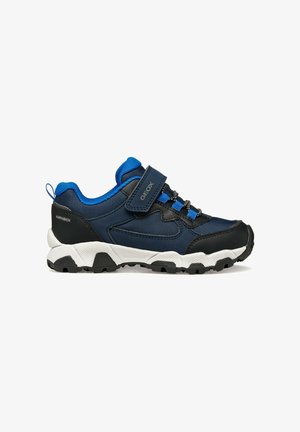 Zapatillas deportivas en azul marino y negro con una tira de Velcro, detalles en azul, parte superior texturizada, suela de goma y dibujo robusto para mayor tracción.