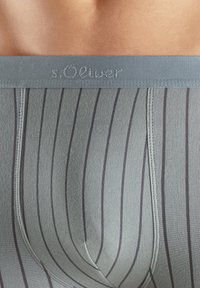 Sivi bokserici s uskim tamnim prugama, od mekog materijala, s elastičnom gumom u struku s logotipom s.Oliver i prilagođenim dizajnom za udobnost.