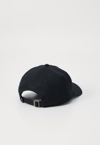 Cappellino da baseball in cotone nero con visiera curva, cinturino regolabile e dettaglio ricamato "EST. 1922" sul retro. Design semplice e privo di ornamenti.