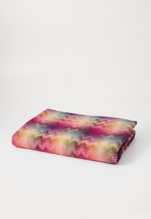 Multicolored woven blanket with a chevron pattern, featuring shades of pink, green, and blue on a soft, textured fabric. Rolled and folded.