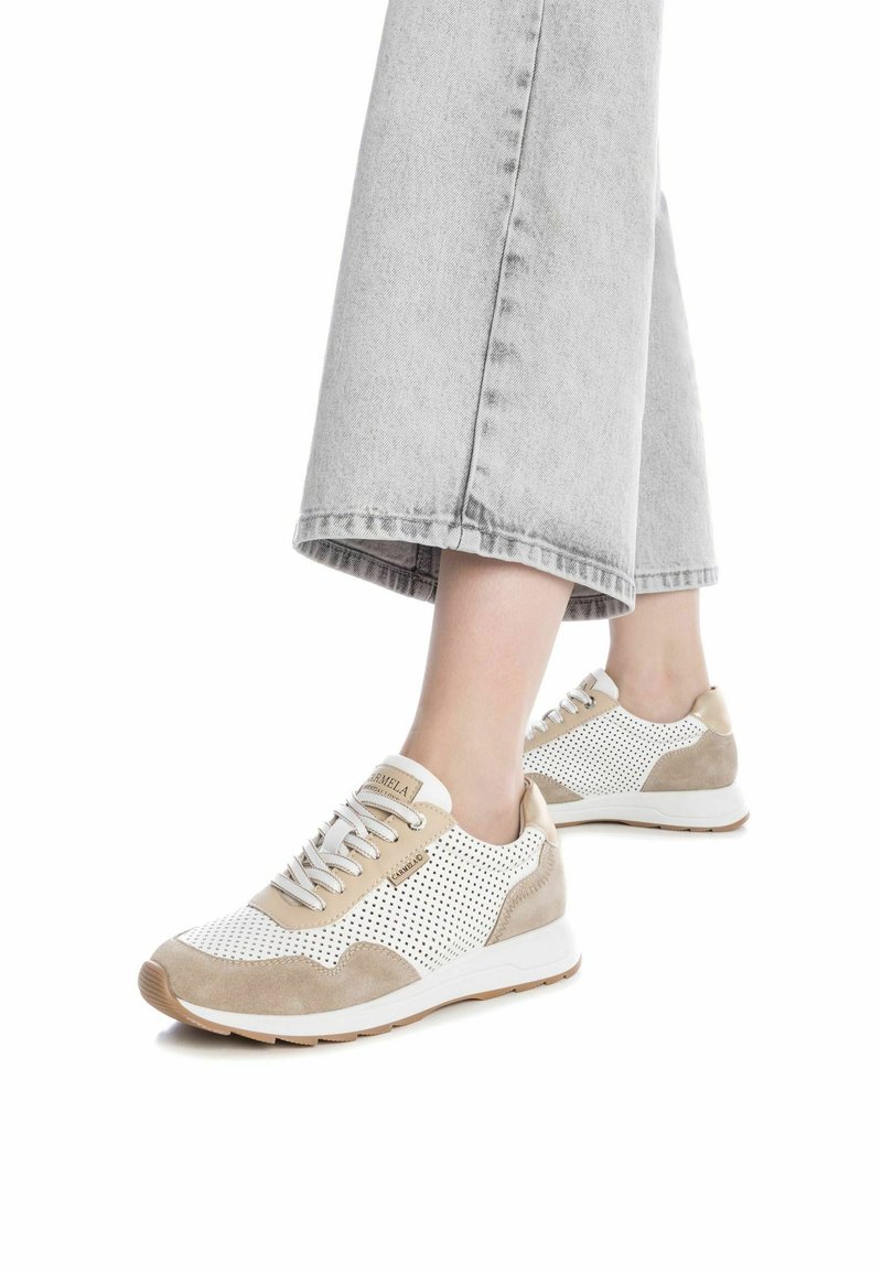 Zapatillas ligeras con una combinación de malla perforada blanca y ante beige. Cuentan con cordones blancos y una suela de goma.