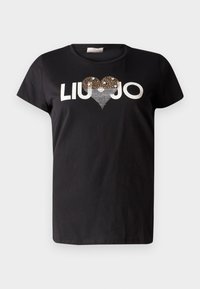 Musta puuvillapaito, jossa on lyhyet hihat, pyöreä kaula-aukko ja sydämenmuotoinen paljettisuunnittelu, jossa on teksti "LIU JO" valkoisella.