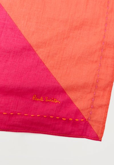 Γωνία ροζ και πορτοκαλί υφάσματος με πορτοκαλί χειροποίητο ράψιμο στα σύνορα και το "Paul Smith" κεντημένο με πορτοκαλί κλωστή.