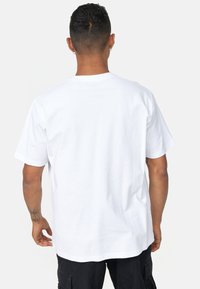 Hvid bomulds T-shirt med korte ærmer og en afslappet pasform, med en klassisk rund hals og uden synlig branding eller mønstre.