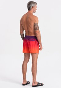 Pánské plavkové šortky v přechodu od oranžové k fialové, s elastickým pasem, boční kapsou a hladkým, lehkým materiálem.