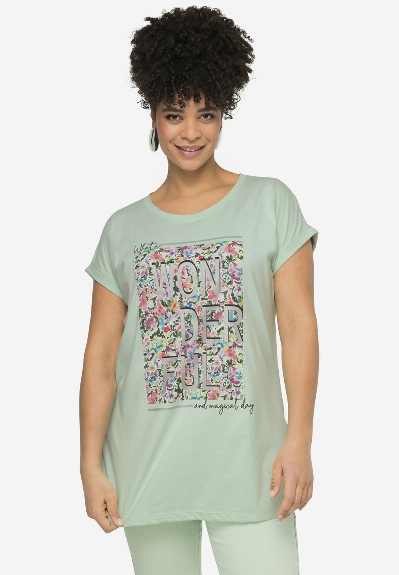 Camiseta de tela suave color verde claro con cuello redondo, mangas cortas, y un diseño gráfico floral que incluye la palabra "MARAVILLOSO" en letras negritas.