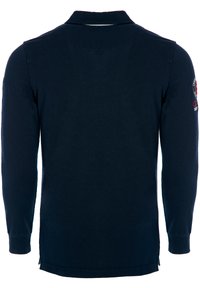 Tumesinise pikakäiselise polo särk, mis on valmistatud puuvillast, ribitud krae ja mansettidega ning vasakul varrukal on tikandiga logo.