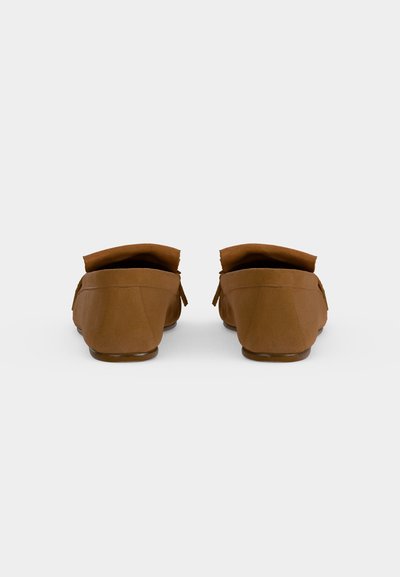 Paire de mocassins en daim brun vue de dos sur fond blanc, mettant en avant les talons bas et les cols pliés.