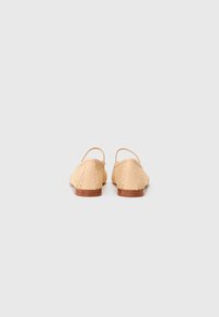 Pantofi slingback bej cu o parte superioară din textil țesut și un fundal din piele netedă. Toc din lemn plat, design simplu fără embellishments vizibile.