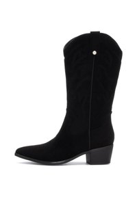 Bota de cowboy de ante negra con punta afilada y tacón bajo, que presenta costuras decorativas y un pequeño botón decorativo en la parte superior.