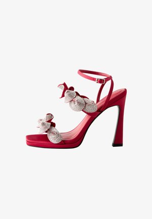 Rode fluwelen sandalen met hoge hakken, voorzien van textuurbedekte bloemversieringen met strasaccenten, een enkelbandje en een vierkante neus.