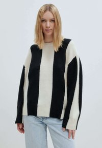 Schwarzer und cremefarbener gestreifter Pullover aus dickem Strickstoff. Verfügt über einen runden Halsausschnitt und lockere Ärmel mit gerippten Bündchen und Saum.