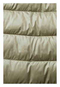 Gros plan sur un tissu matelassé beige brillant avec des coutures horizontales, montrant des sections rembourrées typiques d'une doudoune ou d'un manteau.