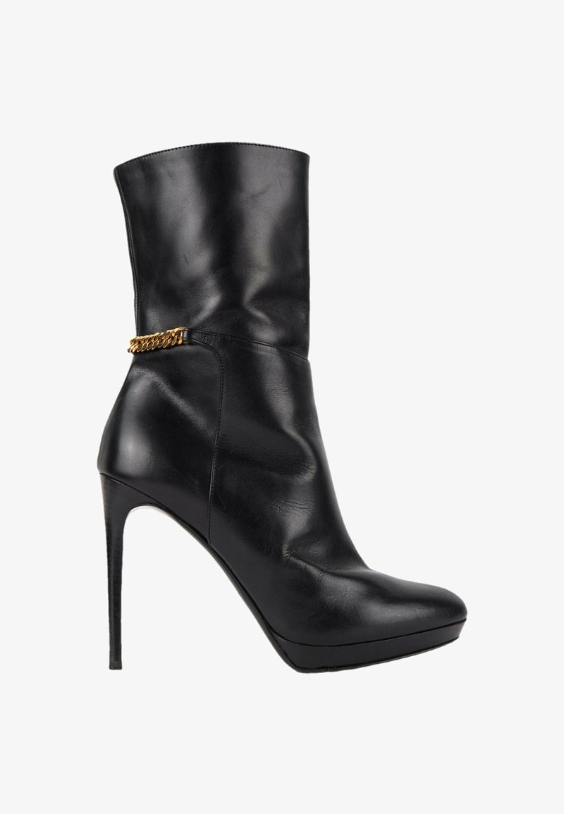 Botte mi-mollet en cuir noir à talon haut aiguillé avec un bout pointu et un fin talon stiletto, ornée d'un petit détail de chaîne dorée à la cheville.