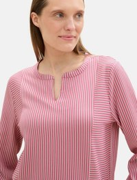 Rosa gestreifte Bluse mit V-Ausschnitt und langen Ärmeln. Verfügt über feine vertikale Streifen in hellen und dunklen Rosatönen. Glatte Textur.