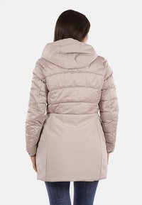 Giacca imbottita beige con cappuccio, caratterizzata da sezioni trapuntate, vita aderente e texture liscia. La vista posteriore mostra una silhouette sagomata.