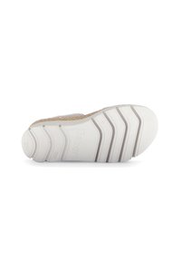 Zool van een schoen met een gestructureerd wit rubber materiaal, prononcerende groeven en een lichtbeige geweven accent langs de rand.