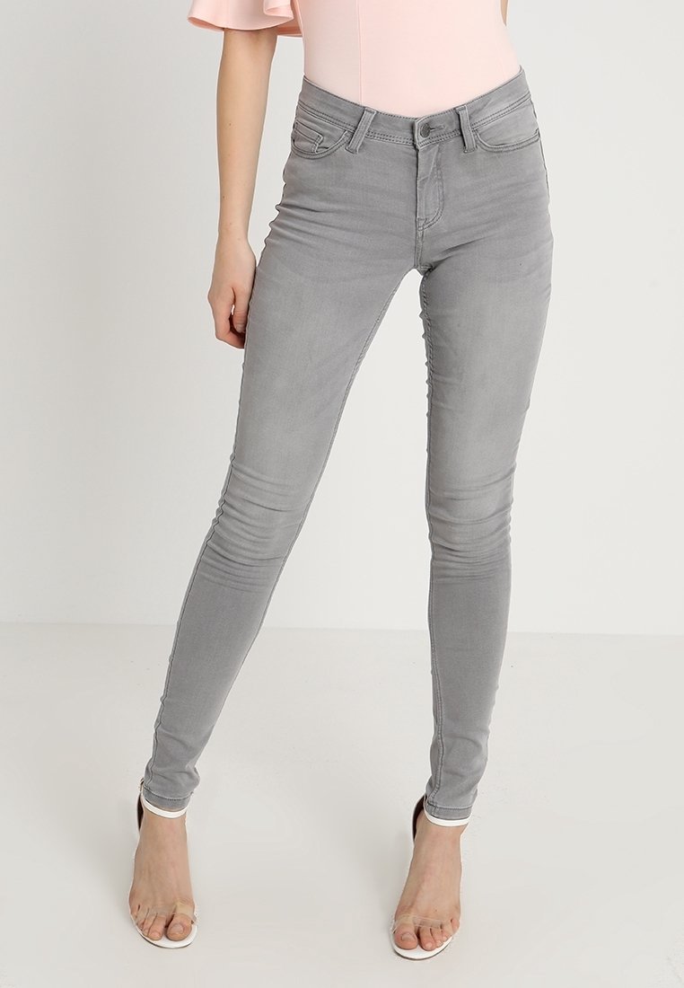 Graue Skinny-Jeans aus Stretch-Denim mit schlankem Schnitt und klassischem Fünf-Taschen-Design, kombiniert mit einem hellrosa Oberteil.