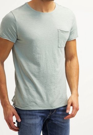 Hellblaues Baumwoll-T-Shirt mit rundem Ausschnitt, kurzen Ärmeln und einer Brusttasche, mit einer weichen, strukturierten Oberfläche.