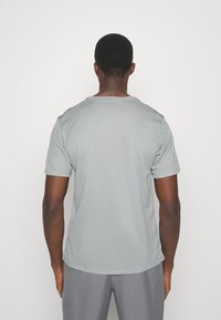 Grå T-shirt med korte ærmer, lavet af glat stof, med en rund halsudskæring og en afslappet pasform. Ingen synlige mønstre eller accenter.
