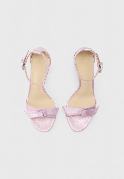 Ζευγάρι ροζ υφασμάτινα σανδάλια με ανοιχτή μύτη, λουράκια στον αστράγαλο και διακοσμητικό φιόγκο σε λευκό φόντο.