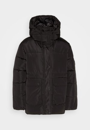 Juoda pūkinė striukė su gaubtu, su priekiniais užtrauktuku ir spaudėmis, dviem priekinėmis kišenėmis ir siūta tekstūra.