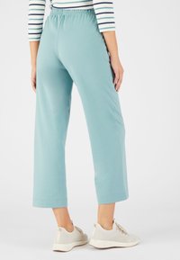 Lichtblauwe, korte sweatpants met een elastische tailleband, met een soepele textuur en rechte pijpen, gecombineerd met lichtgekleurde sneakers.