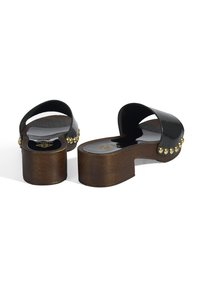 Zwarte gepatineerde leren klompen met een afgeronde neus, houten platformzool en gouden studs langs de rand. Gladde textuur en eenvoudig ontwerp.