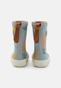 Botas de borracha cinza para chuva com padrões de folhas abstratas multicoloridas, solas brancas e tiras de couro castanho na parte de trás.