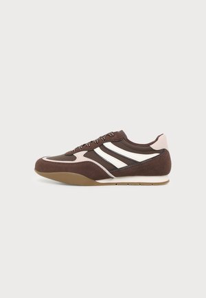 Brązowo-różowy sneaker z białymi paskami, płaską podeszwą i sznurowaniem, pokazany z profilu na jednolitym jasnym tle.