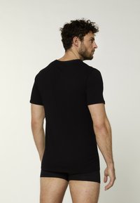 Zwart katoenen T-shirt met korte mouwen en een ronde hals, gladde textuur, aansluitend ontwerp, zonder zichtbare patronen of afbeeldingen.