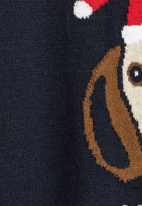 Sweter dzianinowy o ciemnoniebieskim tle, z brązowym rysunkowym psem w czerwonej czapce Świętego Mikołaja oraz białymi akcentami.